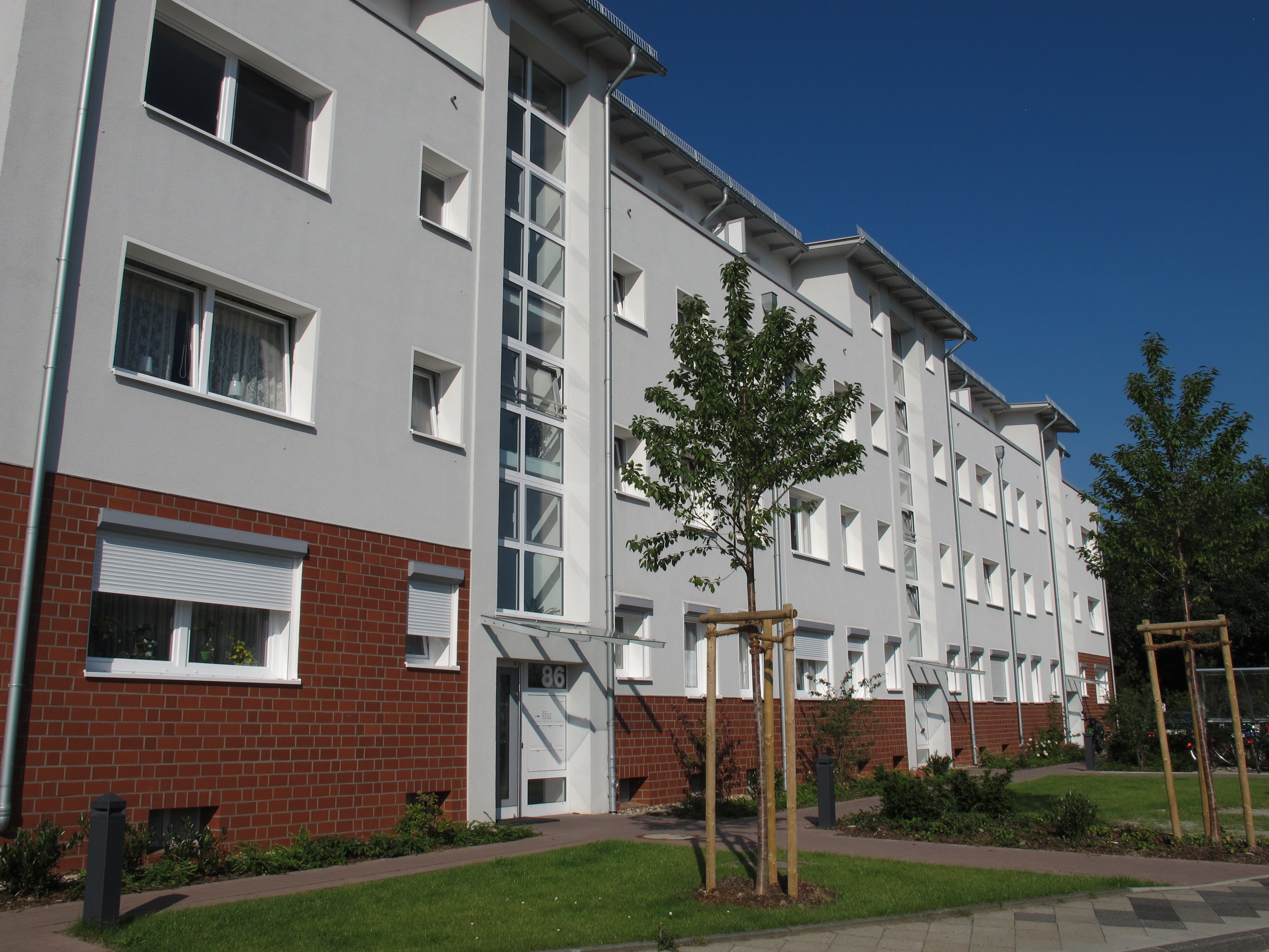 Modernes Wohngebäude mit klar gegliederter Fassade und verglastem Treppenhaus
